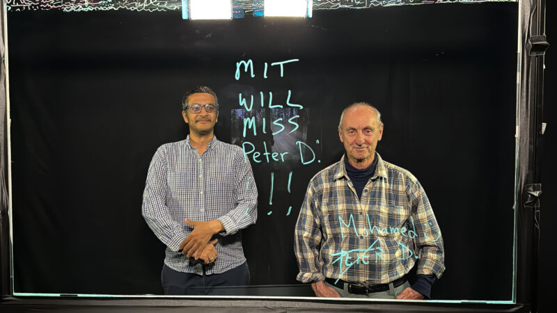 Photo of Mohamed writing a message on the lightboard saying
