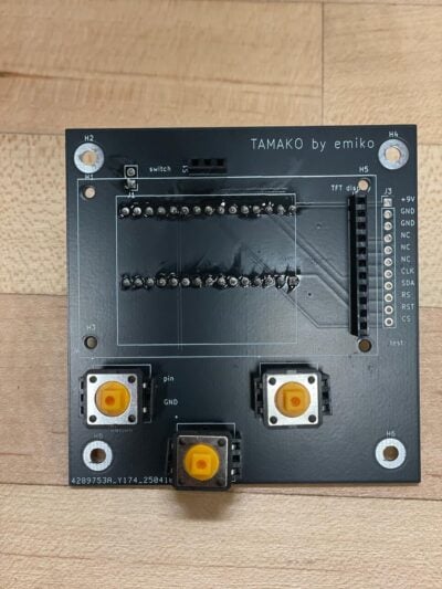 A circuit board with yellow buttons installed. 