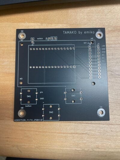 Printed circuit board with many holes on a black surface.