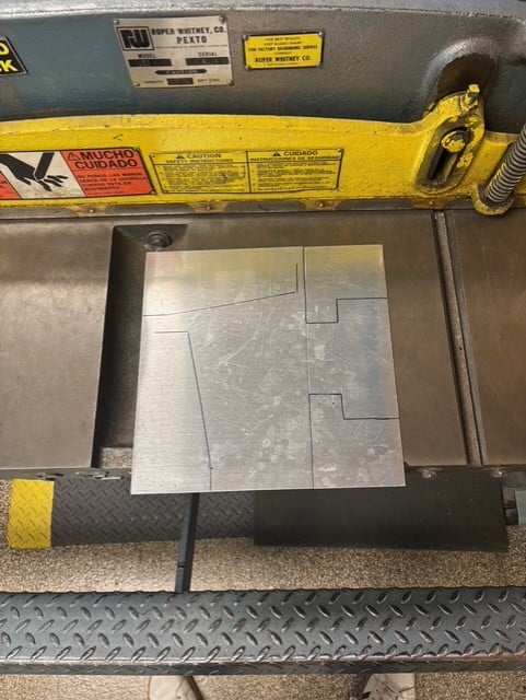 a flat sheet metal with sharpied pattern to cut to make wings and flanges