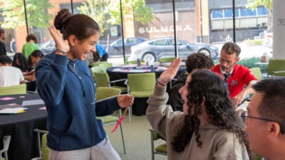 Students high fiving each other.