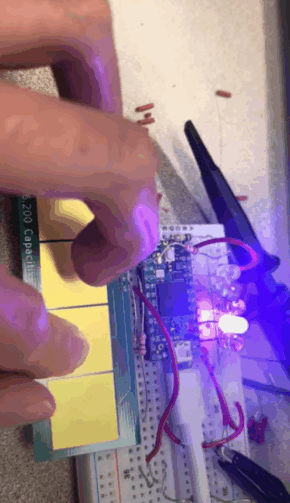 my fingers tapping some buttons, causing LEDs of different colors on a breadboard to illuminate