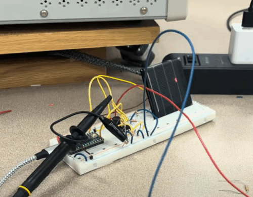 light detector mounted onto a breadboard with chips and wires, with a laser pointed at the detector