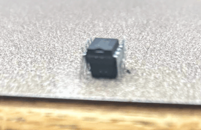 two op-amp chips stacked atop each other on a table, with the bottom one upside-down such that the legs of the op-amps mesh with each other