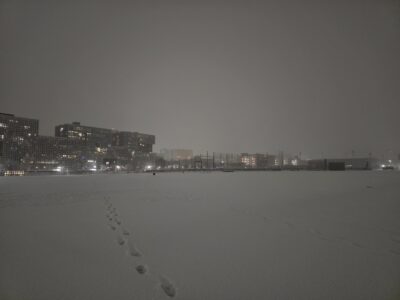 snow covering a field in front of a dorm building