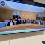 Student standing in front of a digital display.