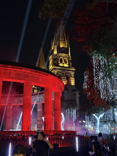 catehdral tower in background with a tholos in front at night