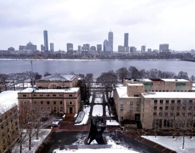brick buildings in foreground covered with snow with river and city in background