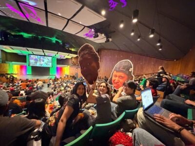 two people in a crowd holding giant cardboard faces