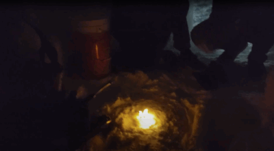 piece of paper on fire in the dark in a circle of snow