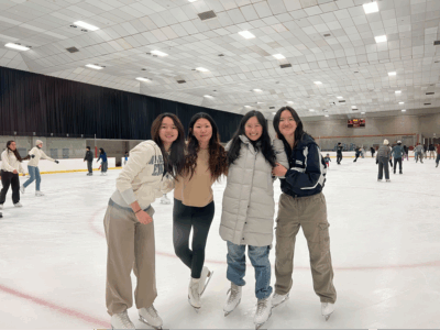 four people posing on ice rink