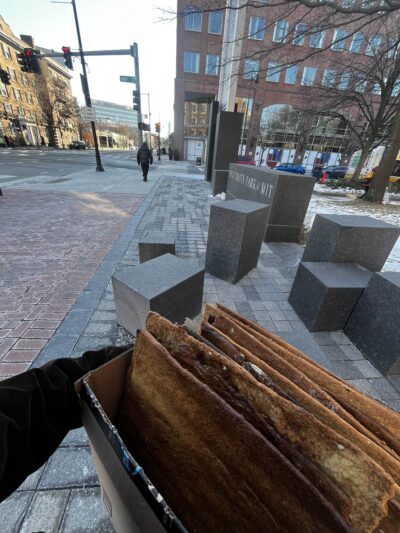 a pov picture of someone holding a cardboard box with a lot of gingerbread in it