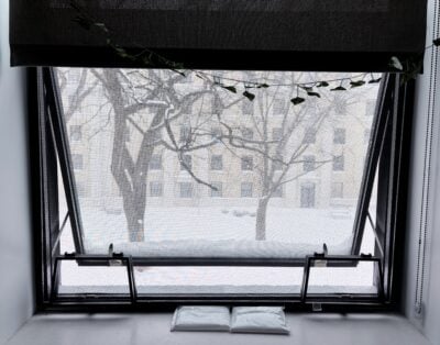 window with snowstorm outside and opposite parallel dorm building in background