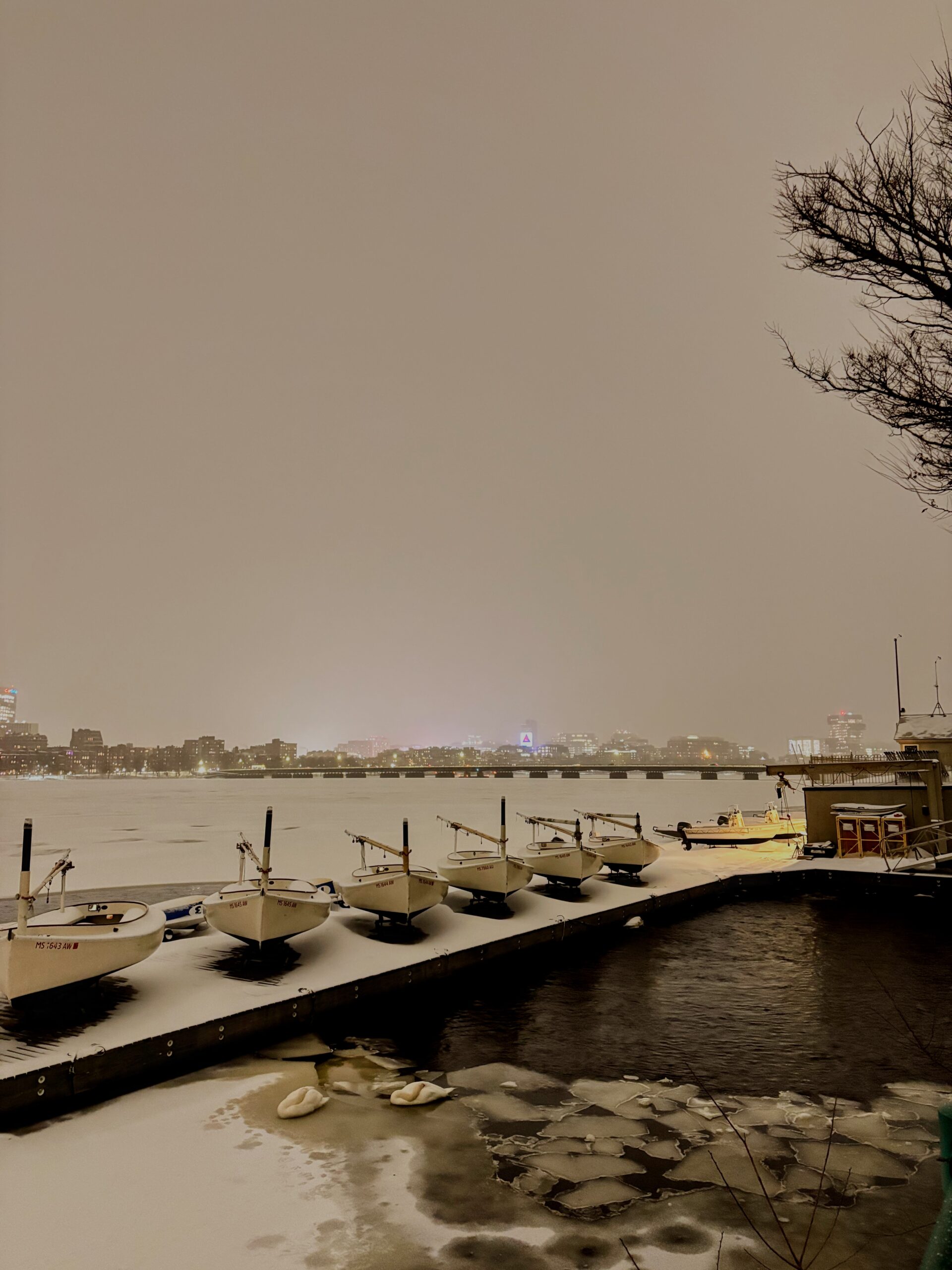 frozen charles river covered in a thick layer of snow, with docks and boats in&hellip;
