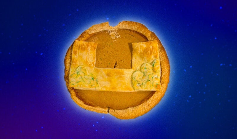 A pumpkin pie with a piece of crust in the shape of the McCormick dorm on top