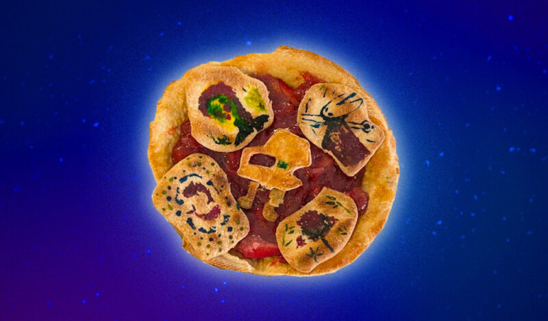 A strawberry pie with chunks of crust depicting a chair and murals on top