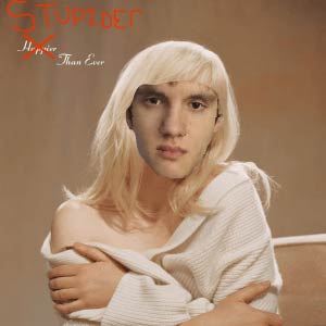 A person with a serene expression, wrapped in a white shawl, against a beige background. Text reads "Stupider" and "Happier Than Ever" in red script.