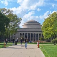 Pathway leading to a grand building with a large dome and columns, flanked by lush&hellip;