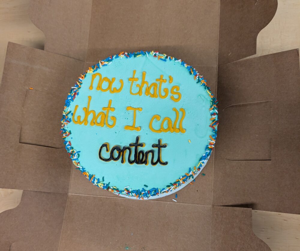 blue cake labelled with "now that's what I call content" in icing