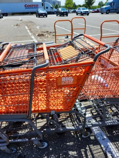 plastic orange shopping cart sandwiched between metal orange carts
