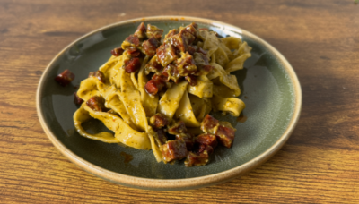 a plate of slightly greenish pasta with chorizo bits scattered on top