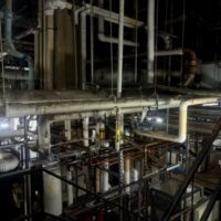 network of curving pipes near the ceiling of a basement against dark background