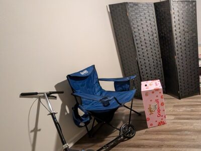 blue foldable camping/lawn chair next to a cardboard box