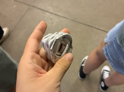 a squiggly metal object produced from the crushing of a metal tube by a hydraulic press