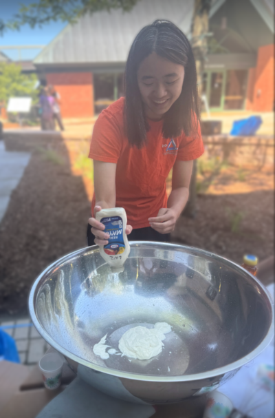 Person pouring mayonnaise into bowl