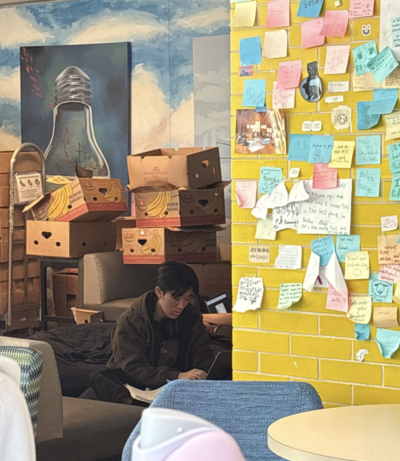 suzuko is working in the banana lounge, wearing his dormspammed brown jacket