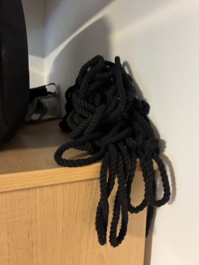 a long tangle of black rope on top of a cabinet