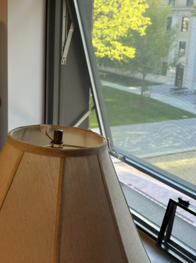 a lampshade next to a window, from which can be seen the east campus courtyard