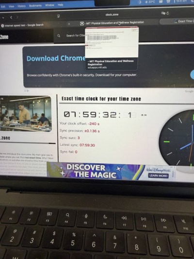Photo of a laptop showing an exact-time clock at 07:59:32 and an MIT Physical Education and Wellness Registration browser tab just before 8am.
