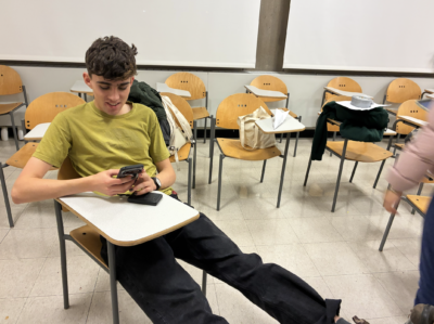 charlie on their phone with their wooden plank skis on