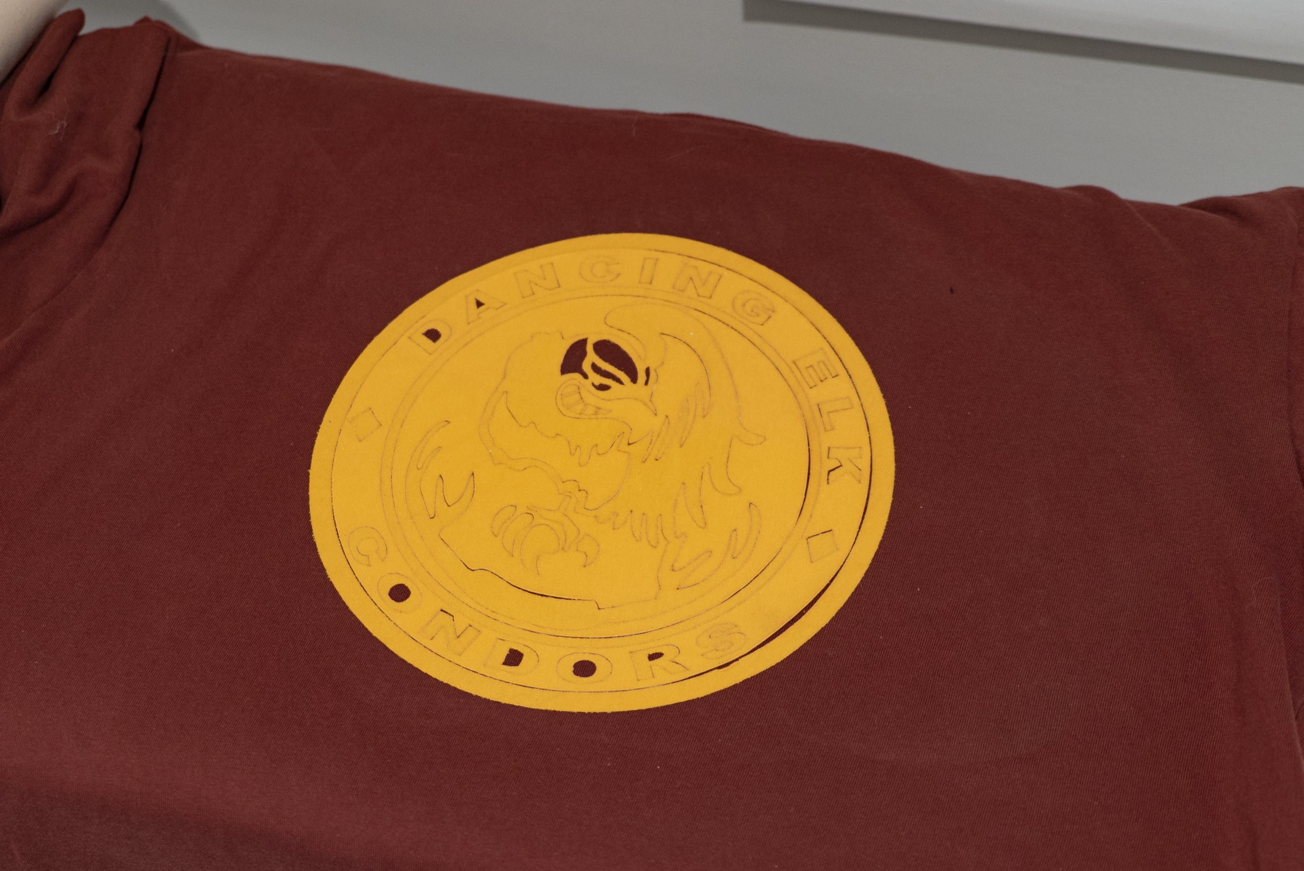 yellow graphic on maroon t-shirt before ironing