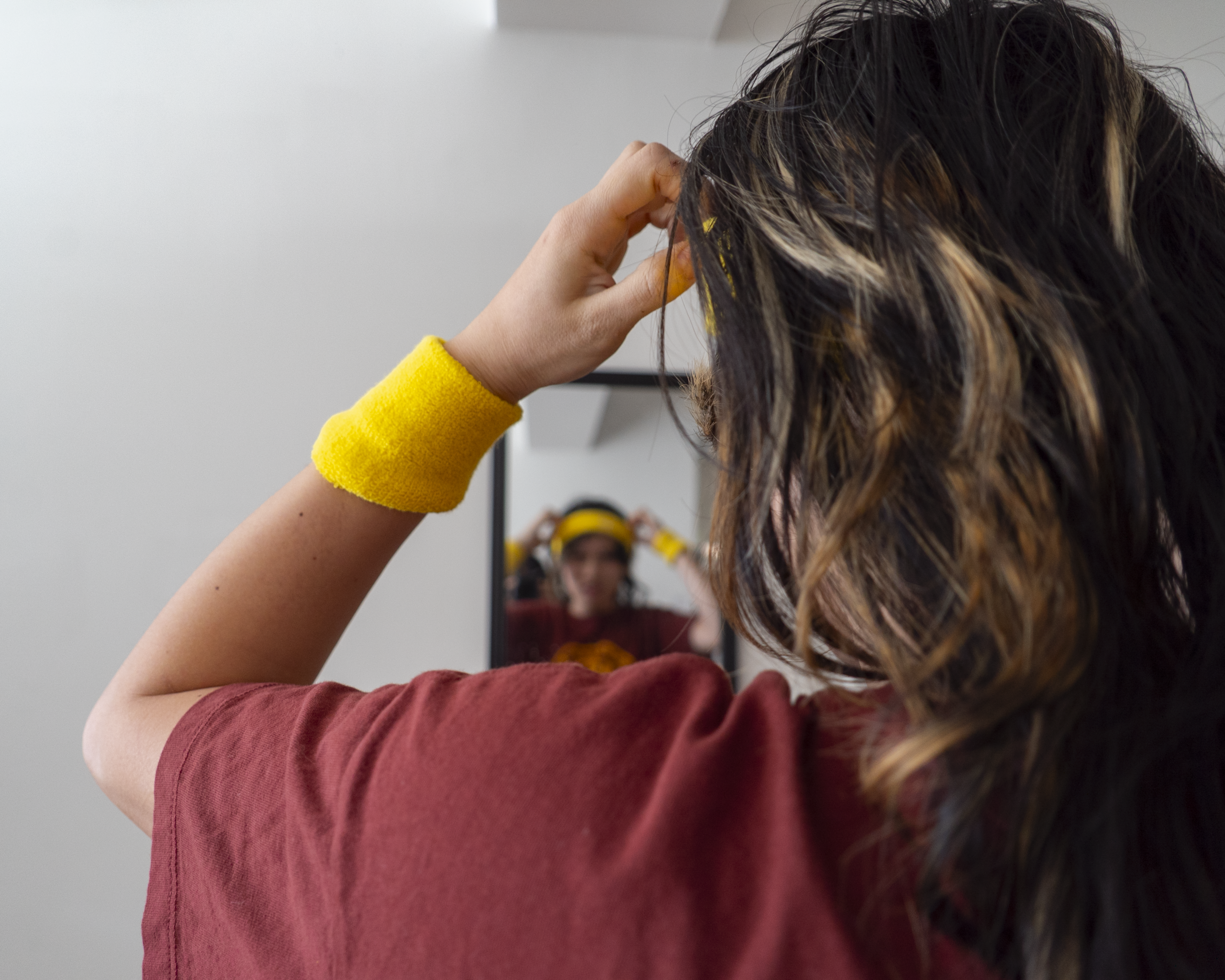 Person putting on headband in front of mirror